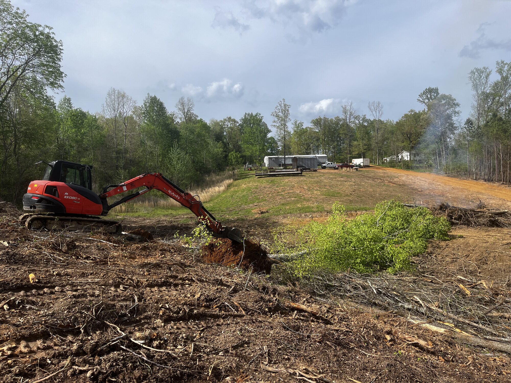 Land Clearing — Kubota KX080 clearing brush and roots on a rural lot Land clearing with Kubota excavator in McNairy County