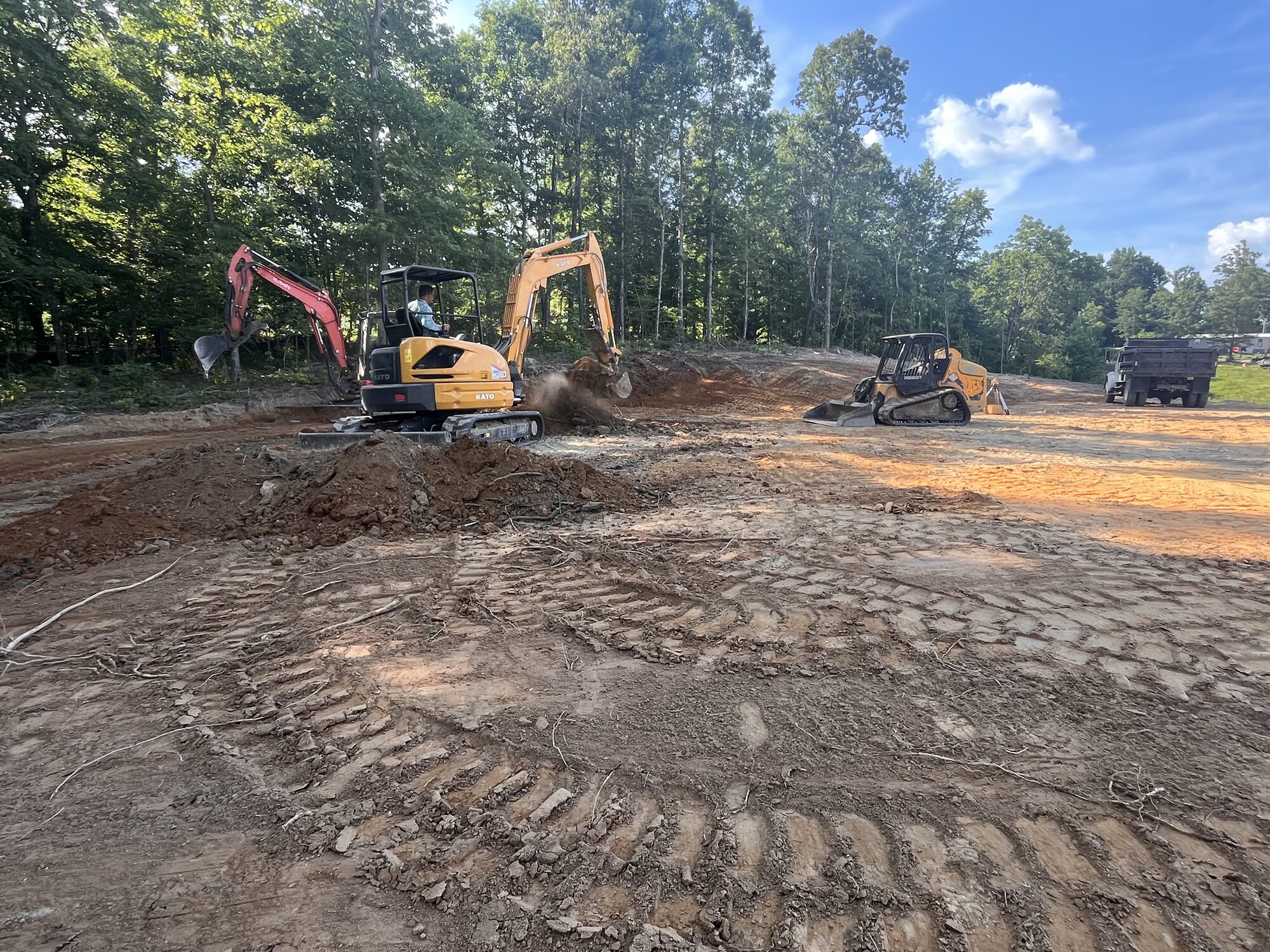 Dirt Work — Excavators + skid steer shaping the building pad Building pad dirt work with excavators near Selmer TN